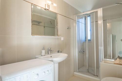 a white bathroom with a sink and a shower at PHAEDRA, Luxury Villa Private Infinity Pool Sea View Stoupa in Exochori