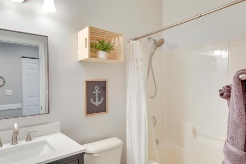 a white bathroom with a shower and a sink at Charleston Condo with Pool Access Near Folly Beach! in Charleston