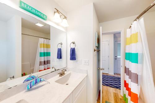 een badkamer met een wastafel en een grote spiegel bij Saylor’s Sandcastle in Surf City