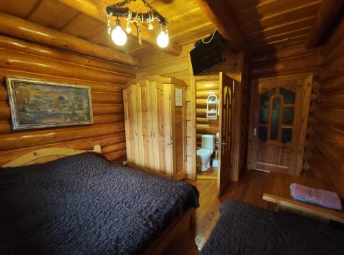 a bedroom with a bed in a log cabin at Дерев'яний котедж "Казка" in Yaremche