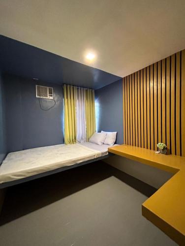 a small room with a bed and a window at Mar Azul Travellers Inn and SPA in San Remigio