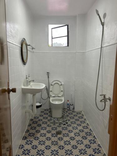a bathroom with a toilet and a sink at Mar Azul Travellers Inn and SPA in San Remigio