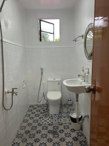 a bathroom with a toilet and a sink at Mar Azul Travellers Inn and SPA in San Remigio