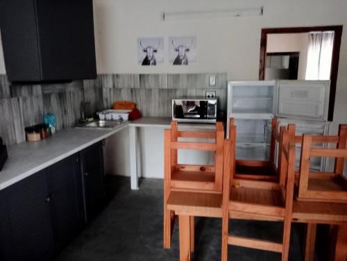 a kitchen with a counter with chairs and a microwave at The beach cottage in Kenton on Sea