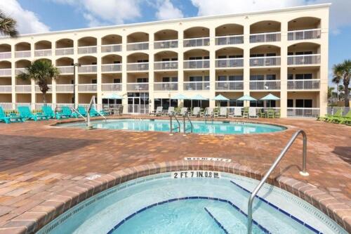 a hotel with a swimming pool in front of a building at Hampton Inn Saint Augustine Beach in Saint Augustine Beach