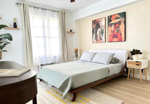 a white bedroom with a bed and a desk at High-End Apartment, Across the Beach in Miami Beach