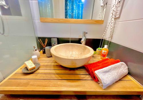 a bathroom with a bowl sink on a wooden counter at Studio Les Alizés du soir St François Rés Anse des rochers équipé avec citerne d'eau in Saint-François