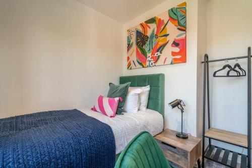 a bedroom with a bed and two green chairs at The Amazing Welsh Oasis! in Newport