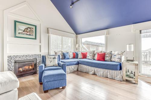 a living room with a blue couch and a fireplace at Cannon Beach Saltbox Cottage in Cannon Beach