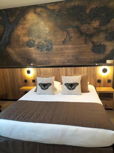a bedroom with a large bed with a wooden wall at France Hôtel in Niort