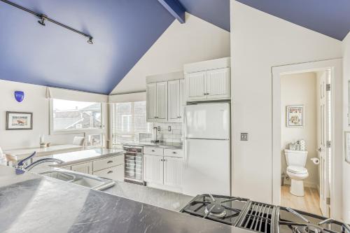 a kitchen with white cabinets and a blue ceiling at Cannon Beach Saltbox Cottage in Cannon Beach