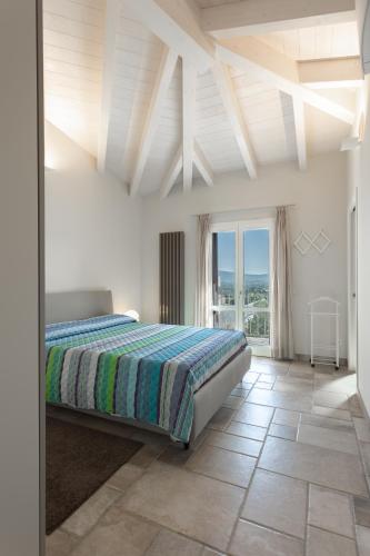 a bedroom with a bed and a large window at Villa the Queen in Budoni