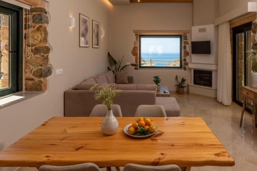 a living room with a table with a bowl of fruit on it at Aoria Villas in Palaiochora