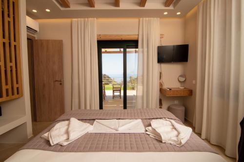 a bedroom with a bed and a sliding glass door at Aoria Villas in Palaiochóra