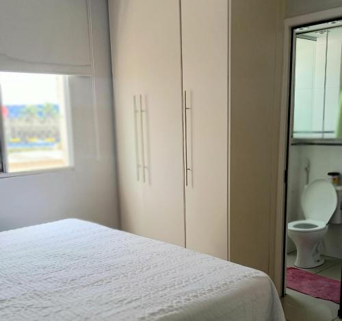 um quarto branco com uma cama e um WC em Apto c/ Ar Wifi Suite Garagem Shopping em Taubaté