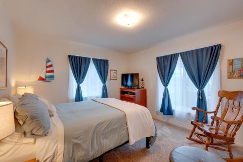 a bedroom with a bed with blue curtains and a chair at Game Room and Patio Charming Jackson Retreat! in Jackson