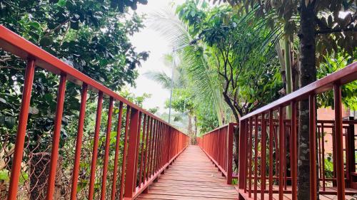 a red bridge in the middle of a forest at Gibbon Singing Home Stay in Quan Tom
