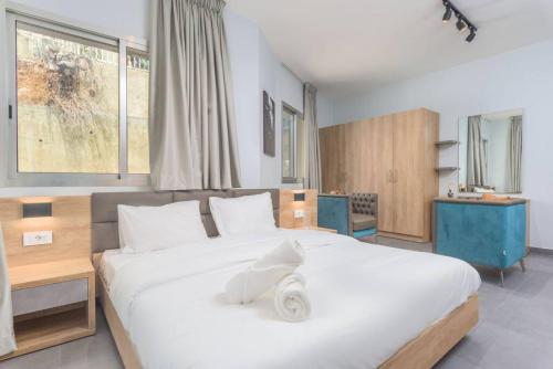 Un dormitorio con una gran cama blanca y una ventana en Vibe 305, Modern 2Bedroom Apartment in Awkar en Dbayeh