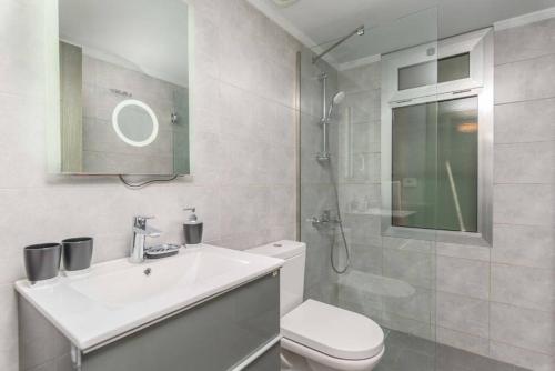 uma casa de banho com um WC, um lavatório e um chuveiro em Vibe 305, Modern 2Bedroom Apartment in Awkar em Dbayeh