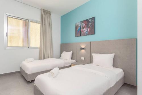 um quarto de hotel com duas camas e uma parede azul em Vibe 205, Modern 2 Bedroom Apartment in Awkar em Dbayeh