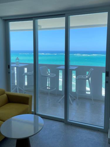 a living room with a view of the ocean at KASA Blue Ocean - 2 bed 2 bath for 4 OCEAN VIEW BALCONY BEACHFRONT CONDO POOL in San Juan