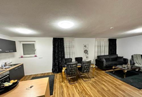 een woonkamer met een bank en een tafel en stoelen bij Luxury Apartment in Neu Ulm