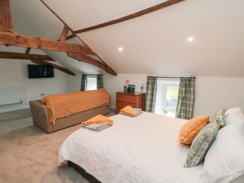 a bedroom with a large bed and a couch at Hawthorn Cottage in Scarborough