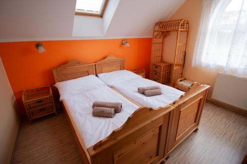 a large bed in a room with an orange wall at Penzion Anebel in Luhačovice