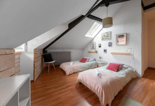 een slaapkamer op zolder met 2 bedden en een bureau bij Grande Maison Cusset - Maison de ville - 3 chambres in Cusset