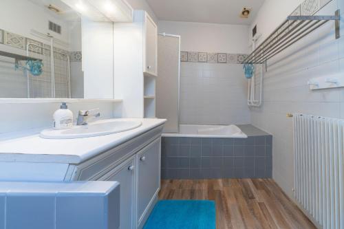 La salle de bains blanche est pourvue d'un lavabo et d'une baignoire. dans l'établissement Grande Maison Cusset - Maison de ville et Studio, à Cusset
