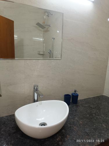 a white sink in a bathroom with a mirror at Moksha at Infinity Valley in Kotagiri