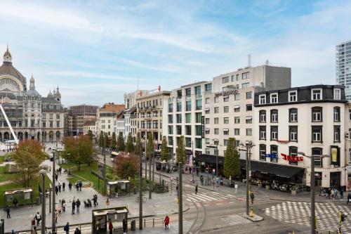 a city with people walking around a street with buildings at Hotel Indigo Antwerp City Centre by IHG in Antwerp