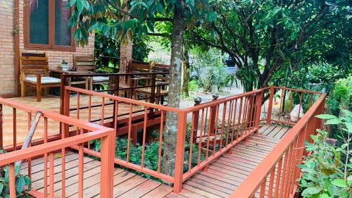 a wooden deck with a table and chairs on a house at Gibbon Singing Home Stay in Quan Tom