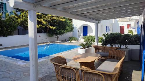 un patio con tavolo e sedie accanto alla piscina di Capari Maisonette Mykonos Town Villa with Shared Pool a Mykonos Città