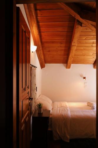 a bedroom with a bed and a wooden ceiling at Diminio 1 Whole House - Chalet in Arachova