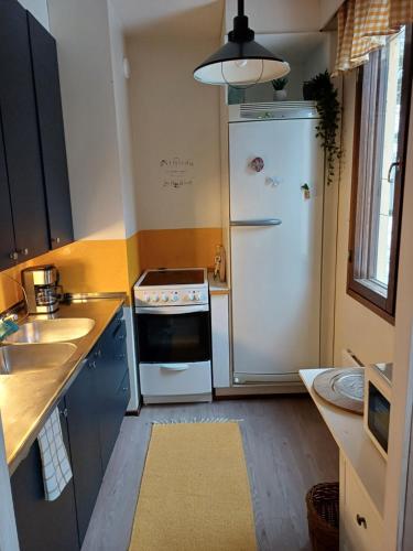 uma cozinha com um fogão e um frigorífico em Meri-Porin lomakoti 