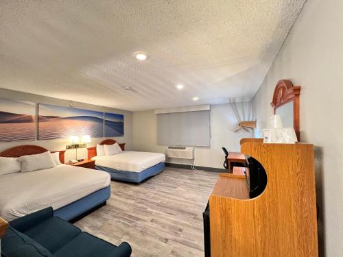 a hotel room with two beds and a flat screen tv at Days Inn by Wyndham Clearfield in Clearfield