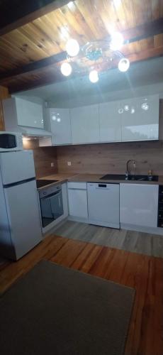 une grande cuisine avec des placards blancs et un évier dans l'établissement haute montage station Orcières merlette draps-ménage en supp sur demande, à Orcières