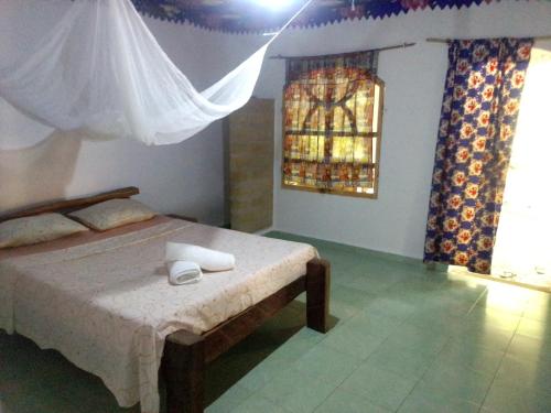 - une chambre avec un lit et une fenêtre dans l'établissement Campement Kunja, à Kafountine
