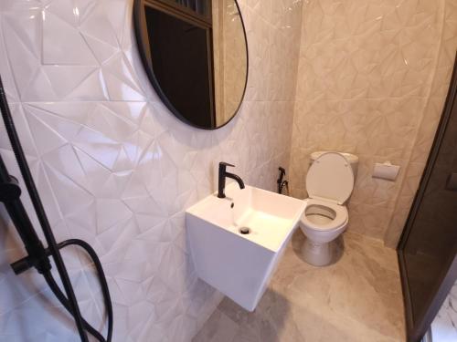北芭堤雅的住宿－Tawan House，一间带水槽、卫生间和镜子的浴室
