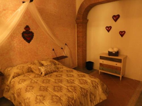 1 dormitorio con 1 cama con corazones en la pared en Mesón del Alcalde, en Lagos de Moreno