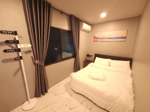a small bedroom with a bed and a window at Tawan House in North Pattaya
