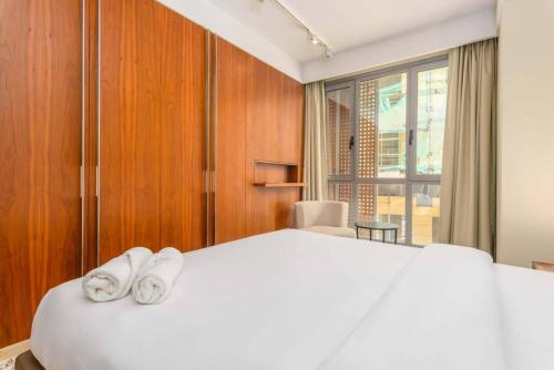 1 dormitorio con 1 cama blanca grande y 2 toallas en Symphony 1 Bedroom Apartment in Solidere, en Beirut