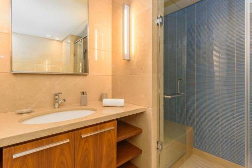 a bathroom with a sink and a shower with a mirror at Symphony 1 Bedroom Apartment in Solidere in Beirut