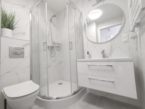 a bathroom with a shower and a toilet and a sink at White Apartament Szklarska Poręba in Szklarska Poręba
