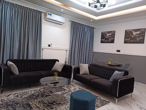 a living room with two couches and a table at Masayi Residences in Adentan