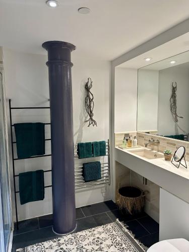 a bathroom with a large sink and a large mirror at Suite4SerenityRWY in Plymouth