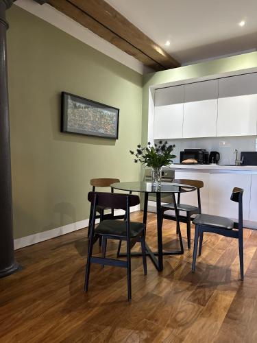 a dining room with a table and chairs and a kitchen at Suite4SerenityRWY in Plymouth
