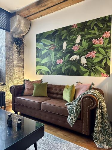 a living room with a brown couch and a painting at Suite4SerenityRWY in Plymouth