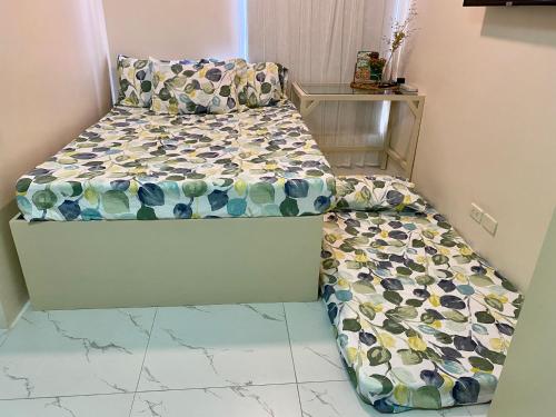 een kleine slaapkamer met een bed met een opvouwbaar matras bij Cozy Studio with Netflix and Pool near Cubao and Greenhills in Manilla